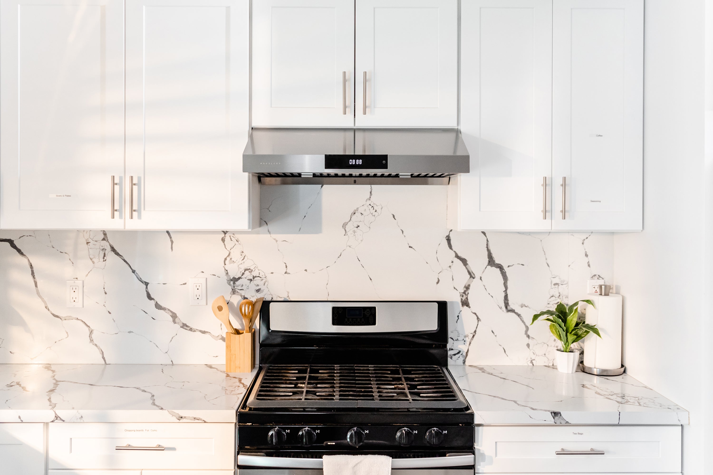 Modern sleek stainless steel under cabinet range hood above the stove.