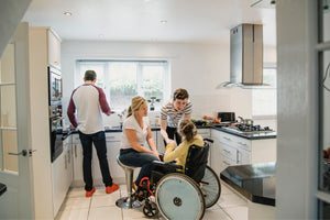 Understanding ADA Compliance for Range Hoods family in the kitchen younger daughter in wheelchair and showing an island range hood