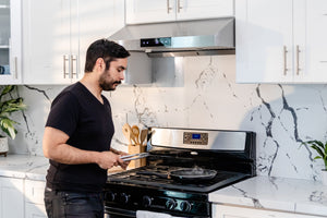 man cooking steak with uc-ps18 hauslane under cabinet range hood