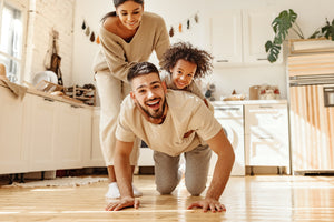 How Flooring and Range Hoods Elevate the Style and Functionality of a Modern Kitchen: Family playing on the kitchen floor with baby