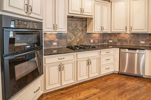 a kitchen with cream color cabinets and double oven