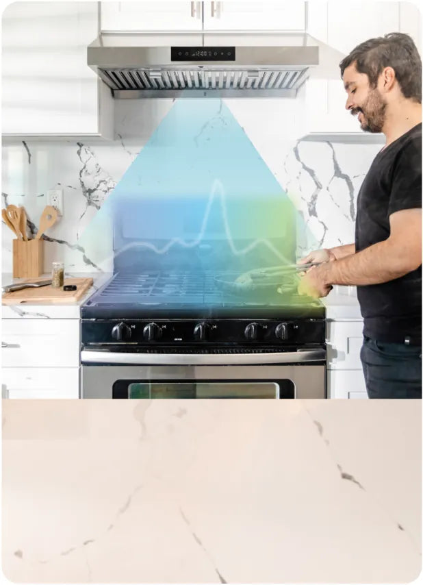 A person cooking hands-free while the hood adjusts its fans.